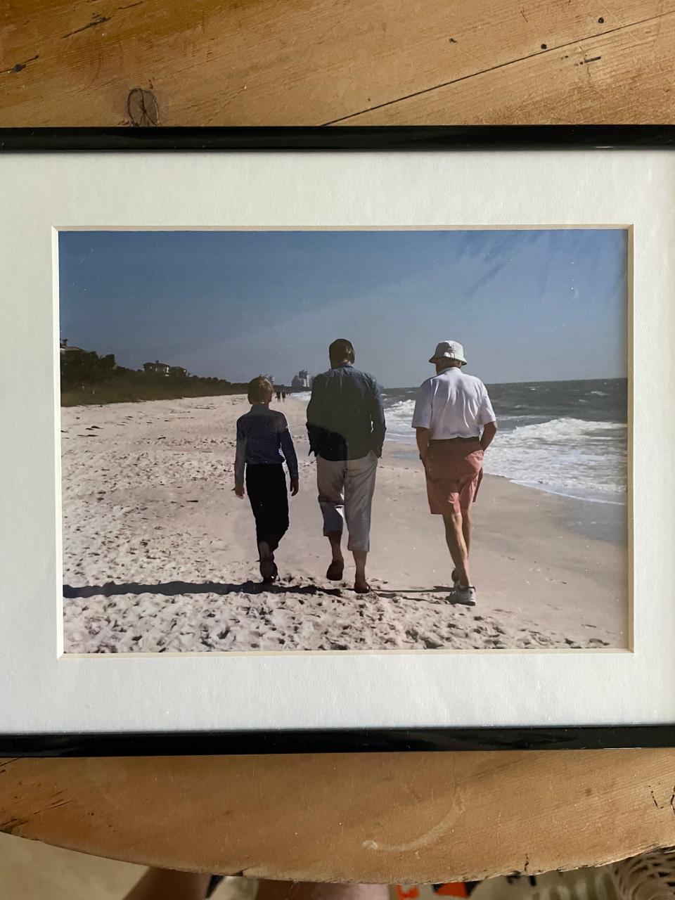 In this undated photo, Carl Sorenson III (right) walks on the beach with his son Carl IV -  who goes by Mike - and grandson Carl V - who goes by Charlie - backs turned to the camera.