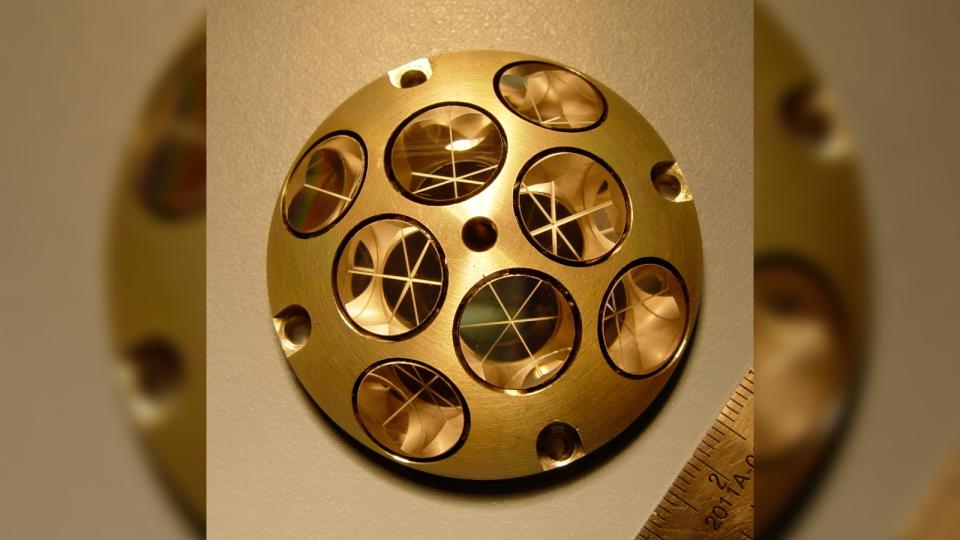 A gold colored semi-sphere covered with 8 round mirrors