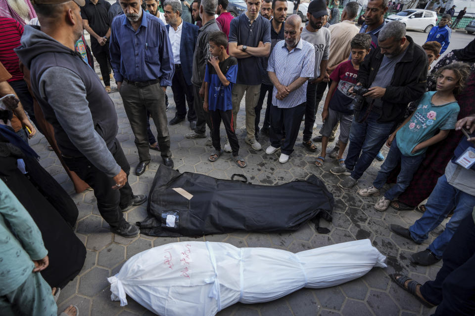 Palestinians mourn their relatives killed in the Israeli bombardments of the Gaza Strip in front of the morgue of the Al Aqsa Hospital in Deir al Balah, Gaza Strip, on Sunday, May 12, 2024. (AP Photo/Abdel Kareem Hana)