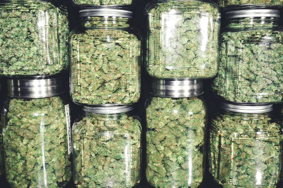 Big canisters of cannabis buds stacked on one another.