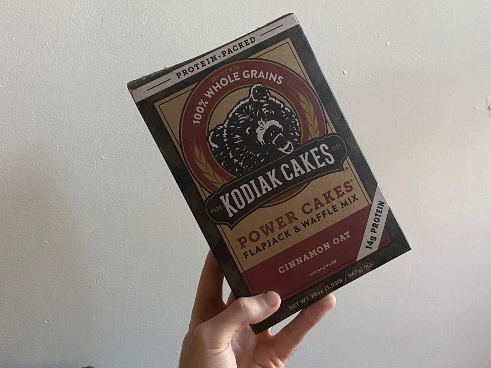 A box of Kodiak Cakes held up in front of a white background