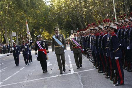 Spain's Crown Prince Felipe (C) reviews troops during a military parade marking Spain's National Day in Madrid October 12, 2013. REUTERS/Juan Medina