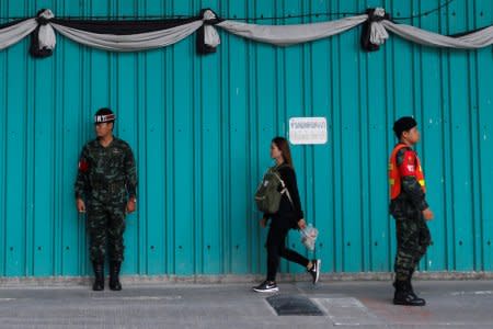 A woman walks past Thai military personnel at the Phramongkutklao Hospital in Bangkok, Thailand, May 23, 2017. REUTERS/Chaiwat Subprasom