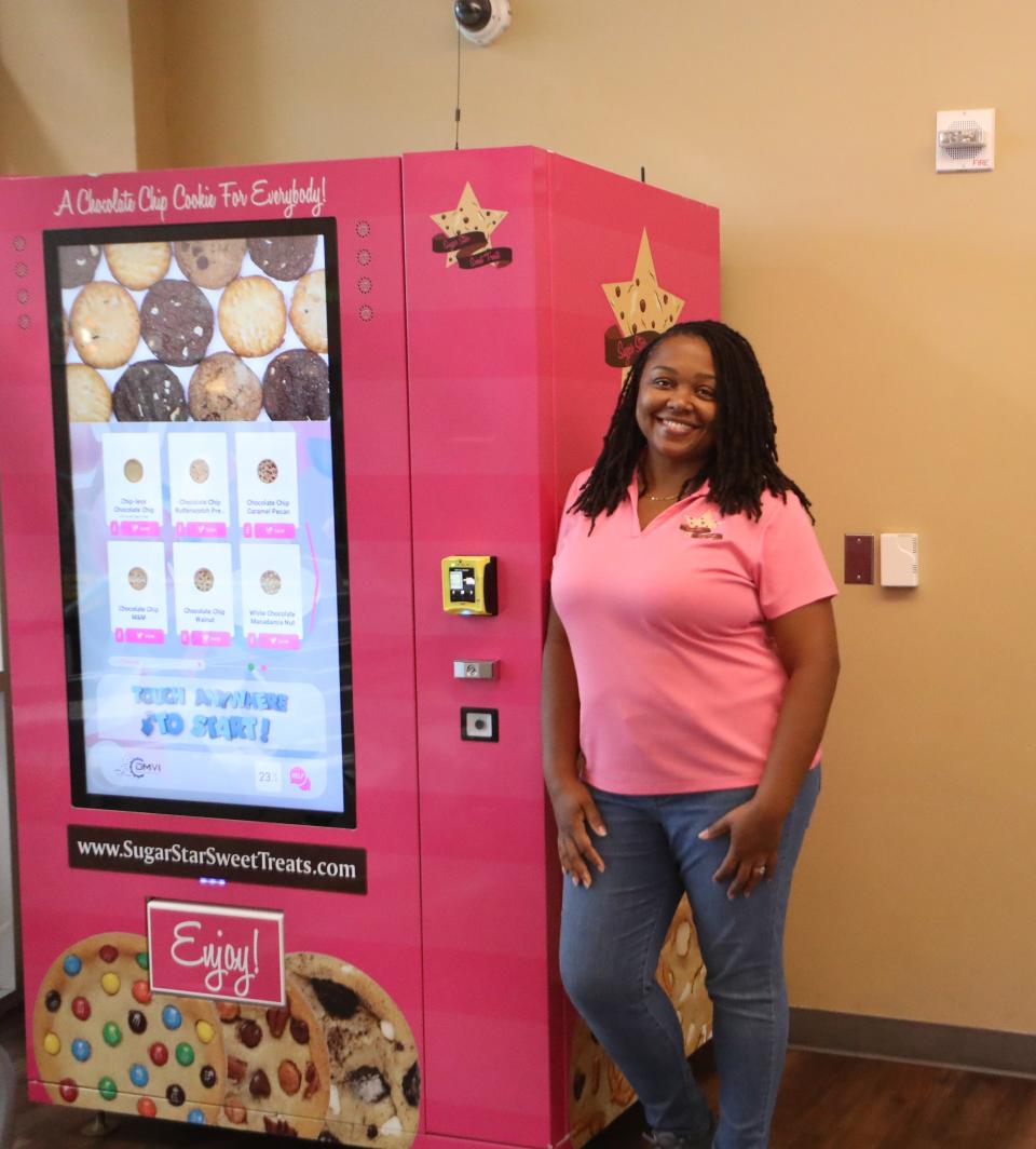 Parshe' Johnson leans against her chocolate chip cookie vending machine at the Salvation Army Ray and Joan Kroc Center in Phoenix on July 26, 2023.