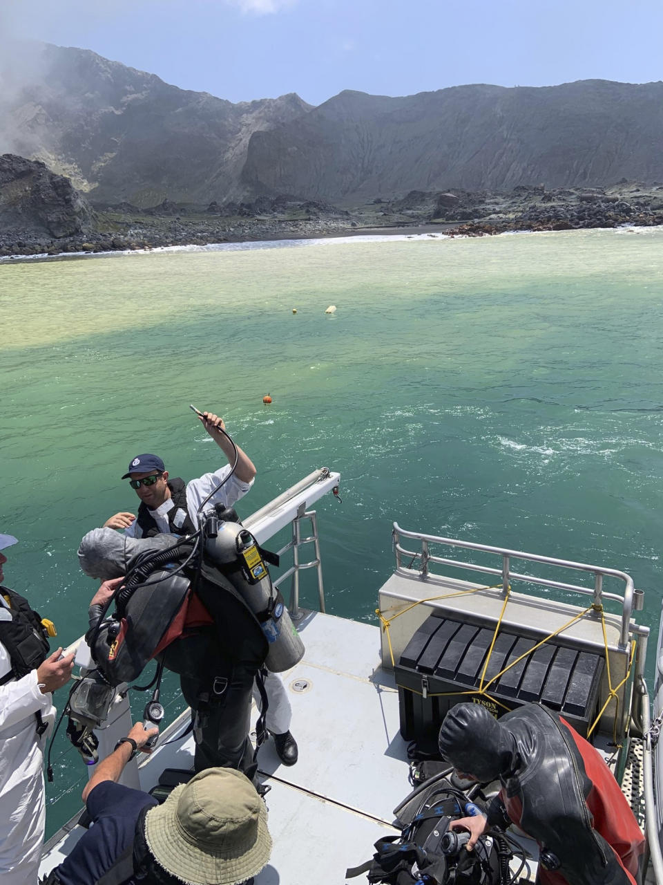 Police divers prepare to search the waters near White Island off the coast of Whakatane, New Zealand, Saturday Dec.14, 2019. A team of nine from the Police National Dive Squad resumed their search early Saturday for a body seen in the water following Monday's volcanic eruption. (New Zealand Police via AP)