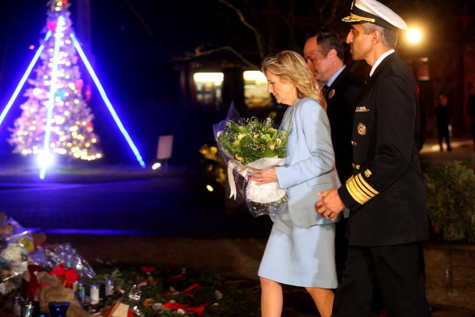 First lady Jill Biden, center, second gentleman Douglas Emhoff, left and U.S. Surgeon Dr. Vivek Murthy, right, pay their respects Wednesday, Dec. 15, at the Waukesha Christmas Parade memorial in Waukesha.