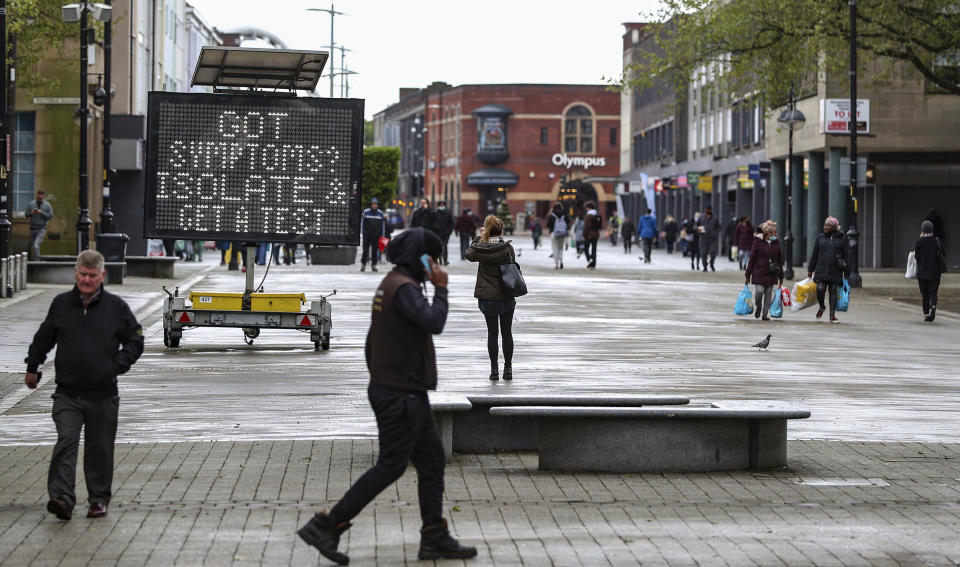 An electronic notice board advises local people to isolate and get tested if they have coronavirus symptoms, in the town centre of Bolton, England, Tuesday May 25, 2021. The British government on Tuesday is facing accusations of introducing local lockdowns by stealth after it published new guidelines for eight areas in England including Bolton, that it says are hotspots for the coronavirus variant first identified in India.Peter Byrne/PA via AP)