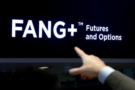 FILE PHOTO: A trader points to a screen that displays FANG+, group of highly-traded technology and tech-enabled companies, on the floor of the New York Stock Exchange (NYSE) in New York, NY, U.S., July 11, 2018. REUTERS/Brendan McDermid/File Photo