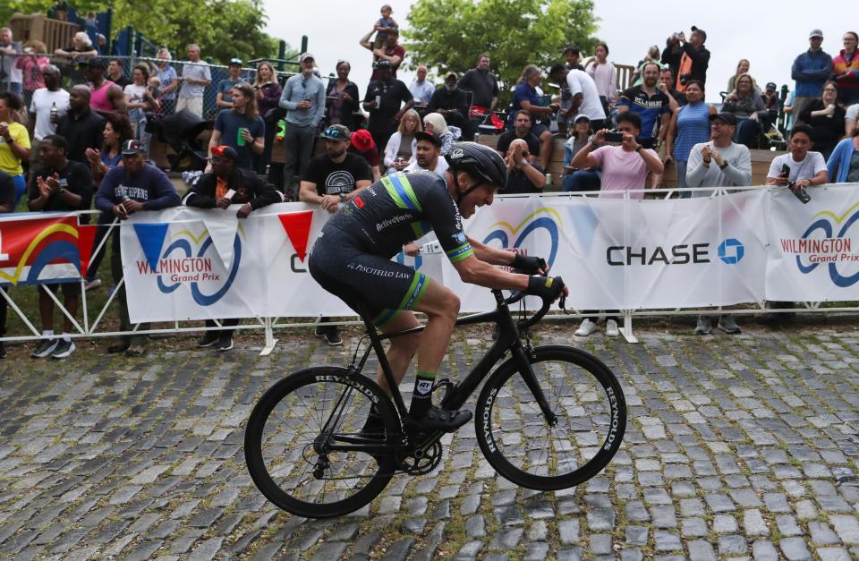 A rider is cheered by race fans clustered near the finish at the top of Brandywine Park's Monkey Hill during the Monkey Hill Time Trial as part of the Wilmington Grand Prix, Friday, May 13, 2022.