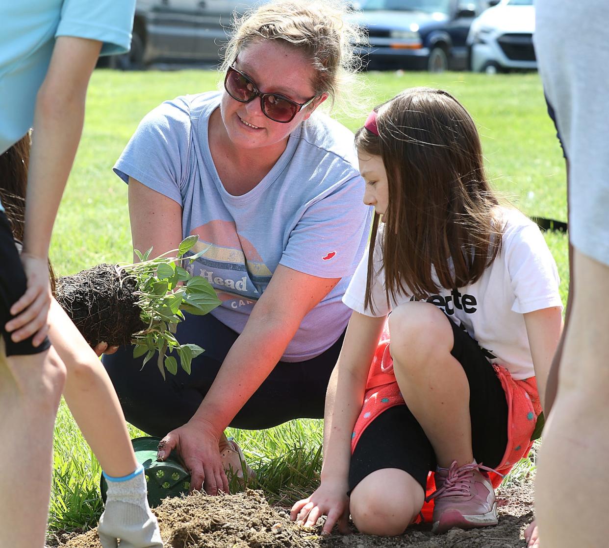 Kate Kedenburg helps Pinewood Elementary 4th grader Alice Russell with planting during an Earth Day event held Friday afternoon, April 19, 2024, at Daimler in Mount Holly.