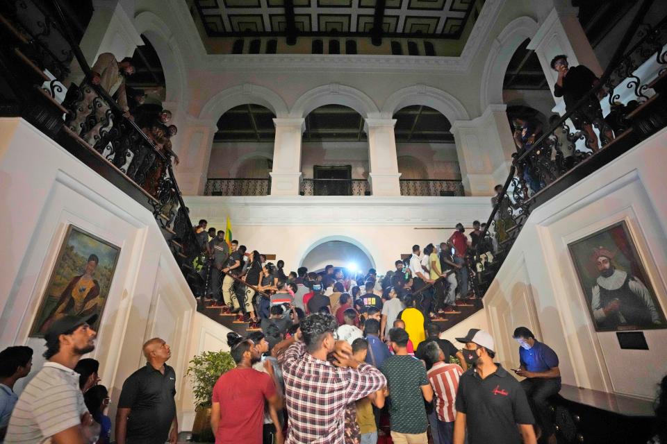 Protesters storm in at the Sri Lankan president's official residence, in Colombo, Sri Lanka, on Saturday, July, 9, 2022. Protesters have broken into the Sri Lankan prime minister's private residence and set it on fire, hours after he said he would resign when a new government is formed over a worsening economic crisis. It was the biggest day of demonstrations that also saw crowds storming the president's home and office.