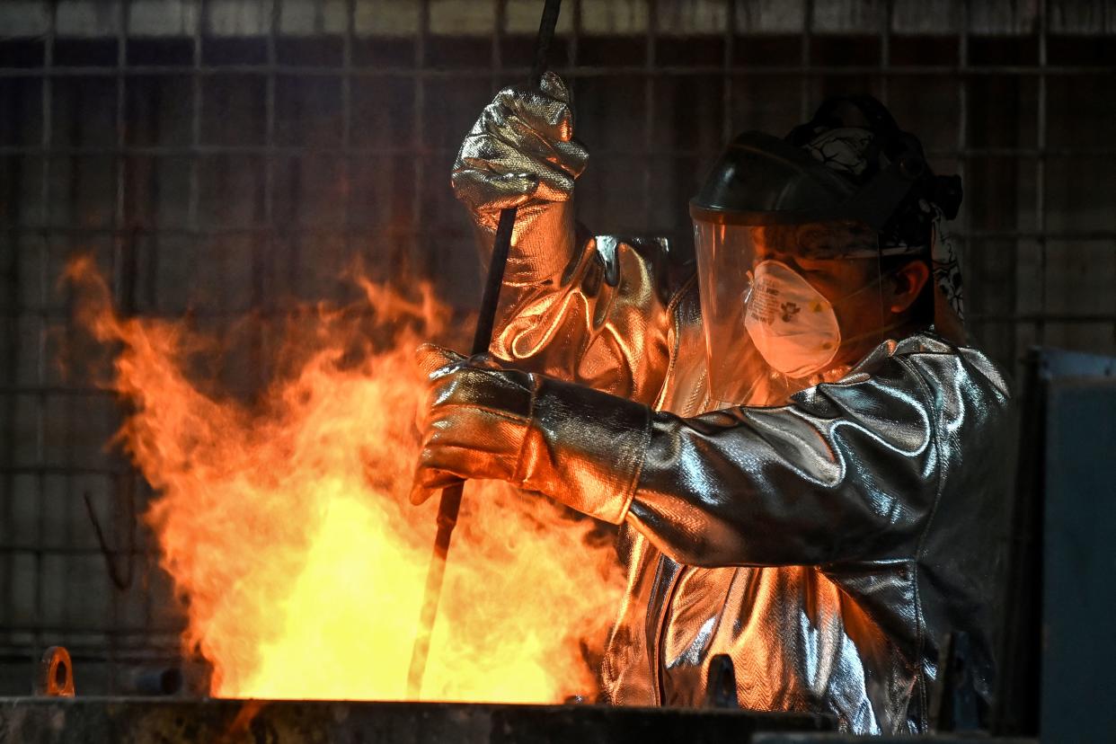 A worker prepares molten gold before it is poured into bars at the Akara Resources Chatree gold mine in Thailand's Phichit province on March 23, 2023. - A controversial gold mine in northern Thailand has restarted, pouring its first bars on March 23, six years after the government ordered it to suspend operations over health and environmental concerns. (Photo by Lillian SUWANRUMPHA / AFP) (Photo by LILLIAN SUWANRUMPHA/AFP via Getty Images)
