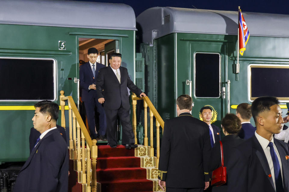 In this photo taken and provided by the Press Office of the Primorsky Krai Region Administration, North Korea's leader Kim Jong Un, center, steps down from his train after crossing the border to Russia at Khasan, about 127 kilometers (79 miles) south of Vladivostok, Russia, Tuesday, Sept. 12, 2023. Kim rolled into Russia on an armored train to see President Vladimir Putin. (Press Office of the Primorsky Krai Region Administration via AP)
