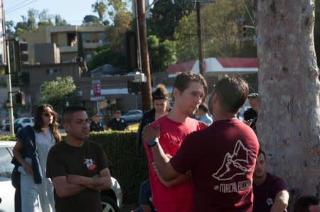 Trader Joe's employees and others wait in a parking lot near a Trader Joe's store where a hostage situation unfolded in Los Angeles, California, July 21, 2018. REUTERS/Andrew Cullen