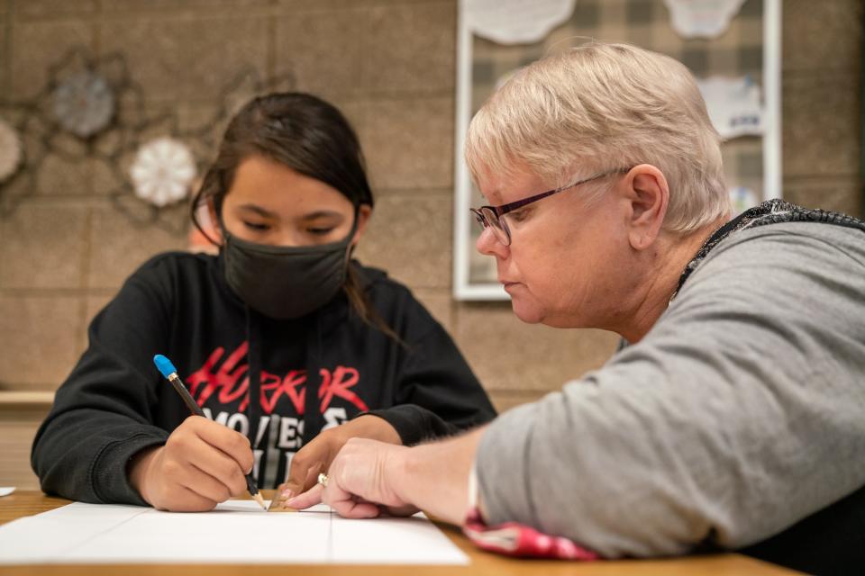 Teacher Sheryl Kohl helps line up a ruler as her student works on an art project. A 37-year veteran of the Poplar school district, Kohl said it's difficult to find and keep enough teachers to stay there.