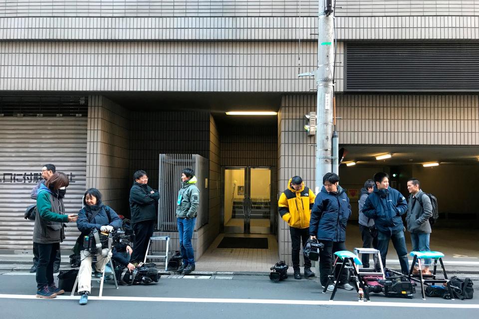 Journalists stake out at the back entrance of a building which houses an office of Junichiro Hironaka, a lawyer for Nissan’s former Chairman Carlos Ghosn, in Tokyo Tuesday, Dec. 31, 2019. Ghosn, who is awaiting trial in Japan on charges of financial misconduct, has arrived in Beirut, a close friend said Monday. He apparently jumped bail. It was not clear how Ghosn, who is of Lebanese origin and holds French and Lebanese passports, left Japan where he was under surveillance and is expected to face trial in April 2020. (AP Photo/Richard Colombo)