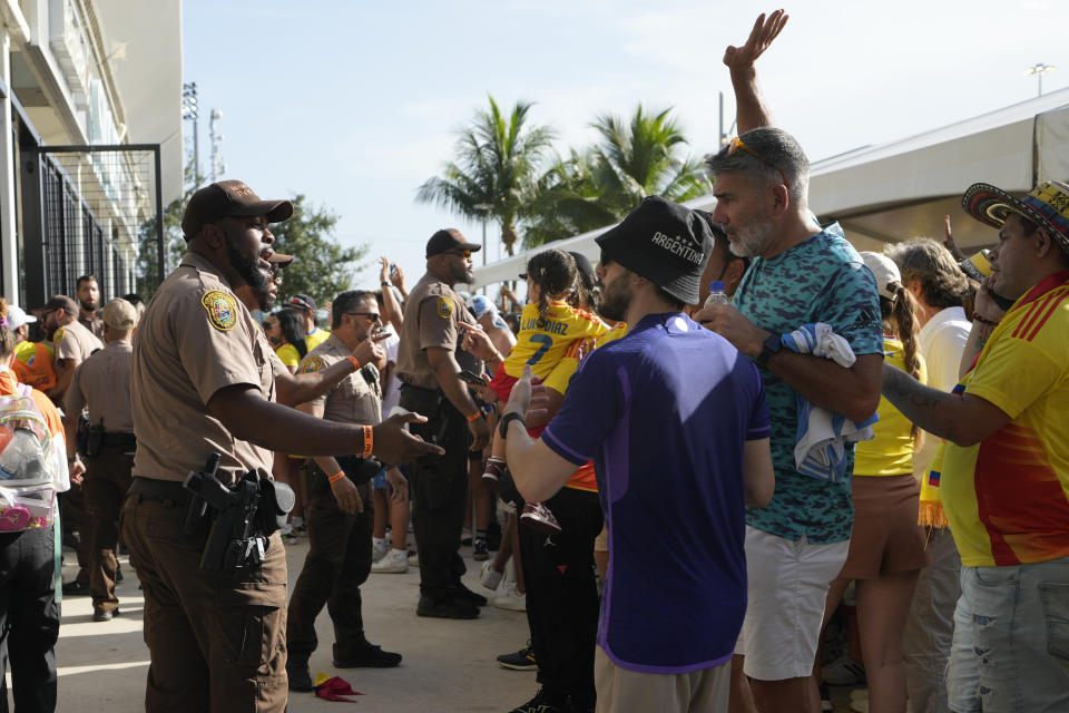 La policía habla con aficionados en la antesala de la final de la Copa América entre Argentina y Colombia, el domingo 14 de julio de 2024, en Miami Gardens, Florida, el domingo 14 de julio de 2024. (AP Foto/Lynne Sladky)