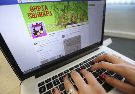 A woman browses the official Facebook page of Greek cartoonist Arkas, which has been restored, in this illustration photo taken in Athens, Greece July 7, 2015. REUTERS/Alkis Konstantinidis