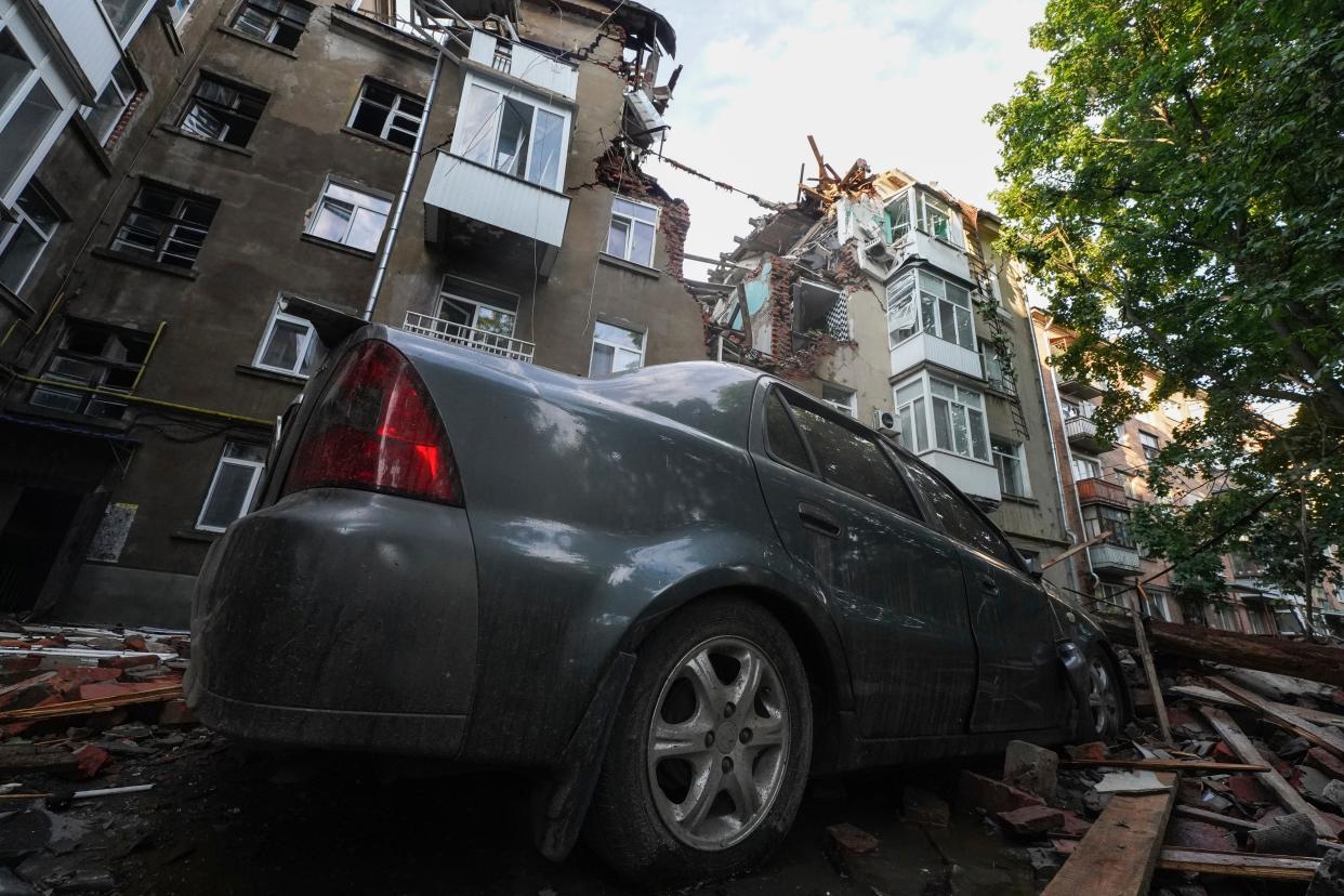 Damages of a car and an apartment building are seen after Russian attack at a residential area in Sumy (AP)