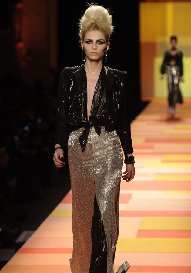 <b>Jean Paul Gaultier SS13 </b><br><br>Dresses featured gold sequins and black top half split to the navel.<br><br>© Rex