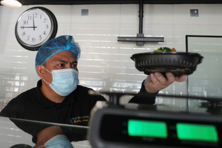 Un trabajador de un restaurante de Riad pesa un plato para un cliente a dieta el 12 de febrero de 2023 (Fayez Nureldine)