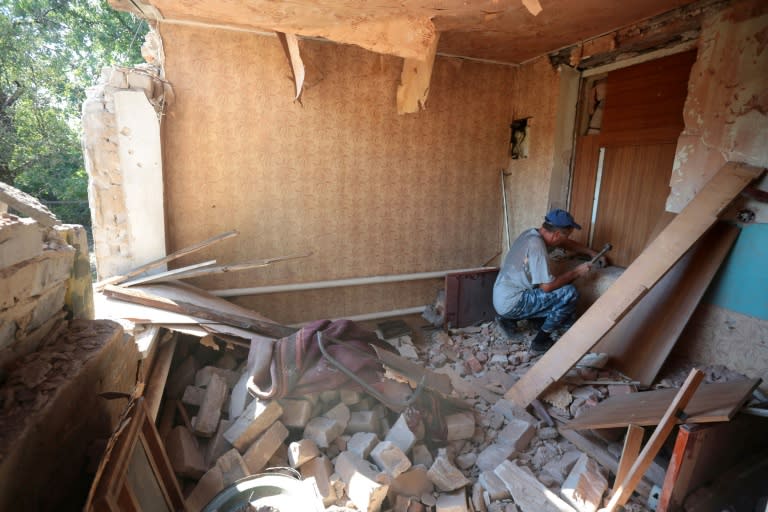 A man reapairs his house destroyed as a result of shelling in Donetsk, eastern Ukraine, on September 19, 2016