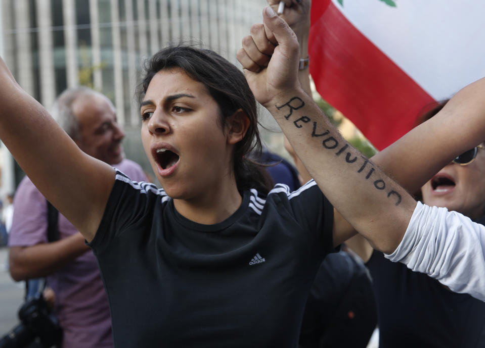 An anti-government protester shots slogans after she was attacked by Hezbollah supporters, in Beirut, Lebanon, Tuesday, Oct. 29, 2019. Lebanon's prime minister resigned, bowing to one of the central demands of the protesters. The news came shortly after baton-wielding Hezbollah supporters rampaged through the main protest camp in Beirut, torching tents and chasing away demonstrators. (AP Photo/Hussein Malla)