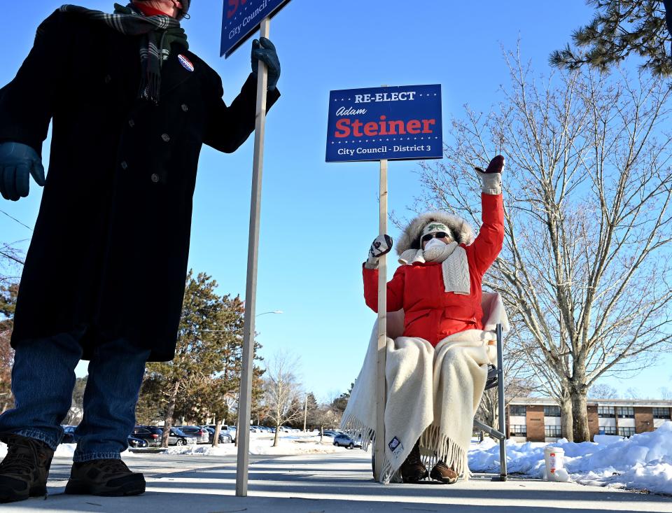 Maureen Dunne of Framingham is well bundled for the bitter cold as she campaigns on behalf of her son-in-law, District 3 City Councilor Adam Steiner, at the Brophy Elementary School, Jan. 11, 2021.  A recount after  the Nov. 2 municipal election resulted in a tie between Steiner and challenger Mary Kate Feeney and a "failure to elect."  A Middlesex Superior Court judge ruled that a special election was the fairest way to determine the outcome.