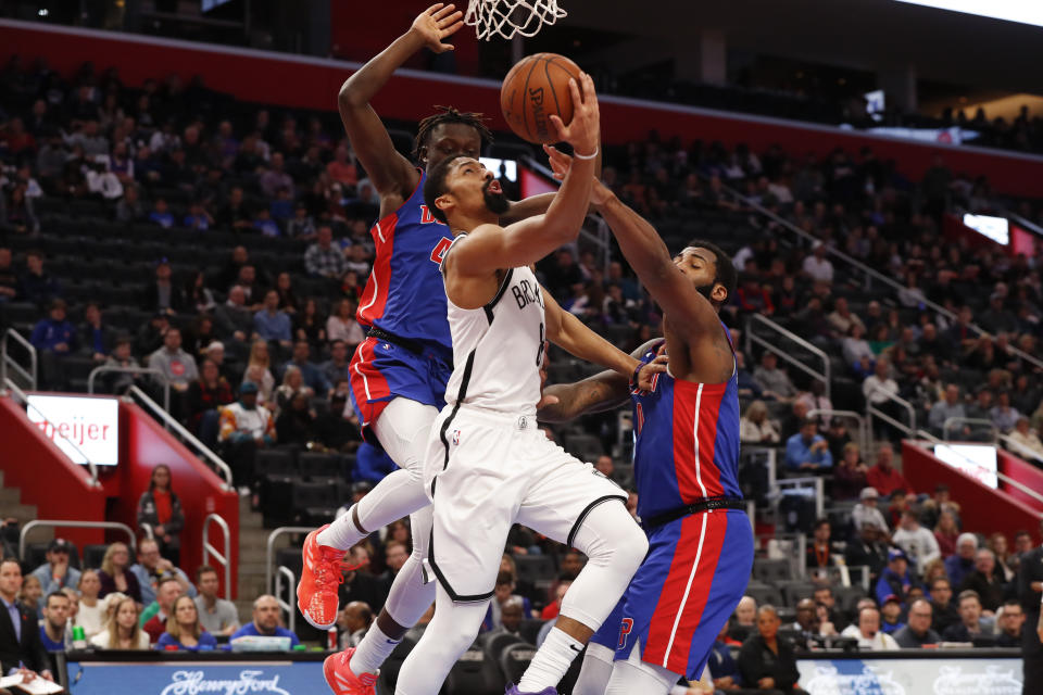 Brooklyn Nets guard Spencer Dinwiddie (8) drives on Detroit Pistons forward Sekou Doumbouya, left, and Andre Drummond, right, in the first half of an NBA basketball game in Detroit, Saturday, Jan. 25, 2020. (AP Photo/Paul Sancya)