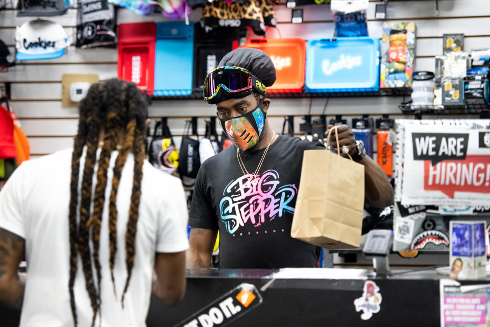 Small business owner Birl Hicks helps a customer at Columbia Place Mall in Columbia, South Carolina on April 24, 2020. | Sean Rayford—Getty Images