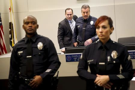 Police Chief Charlie Beck (rear R) and inspector general Alexander A. Bustamante, (rear L) walk out after protests against the death of Ezell Ford erupted in the audience inside the meeting of the Los Angeles Police Commission in Los Angeles, California June 9, 2015. REUTERS/Patrick T. Fallon