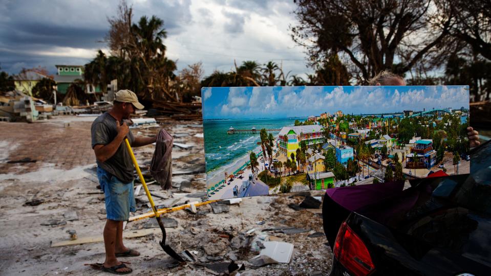 In October 2022, Debi Szekely displays a picture of Fort Myers Beach that was recovered from her home on Hibiscus Drive on Fort Myers Beach. The neighborhood was heavily impacted by Hurricane Ian. Many homes were destroyed and all of them sustained major flooding. She and her husband Tim were cleaning up and looking through the wreckage.