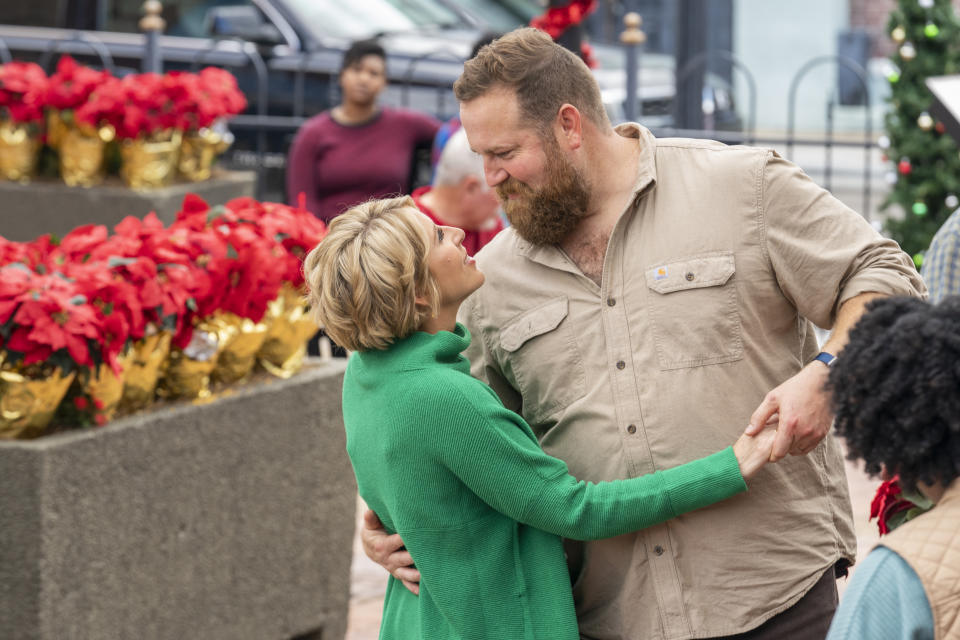 This image released by HGTV shows Erin Napier and Ben Napier Henry, who restore homes on HGTV's “Home Town," in a scene from the holiday special "A Christmas Open House,” airing Wednesday, Dec. 7. (Erik Voake/HGTV via AP)