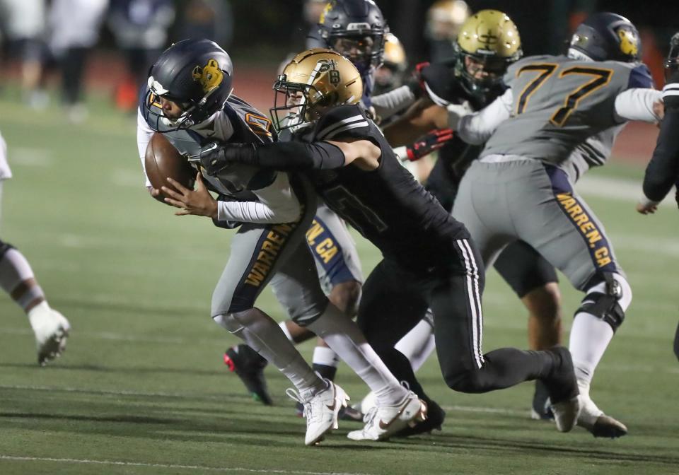 Warren quarterback Madden Iamaleava is taken down by St. Bonaventure's Matt Perez during the Seraphs' 24-21 win in the CIF-SS Division 3 championship game on Nov. 25.