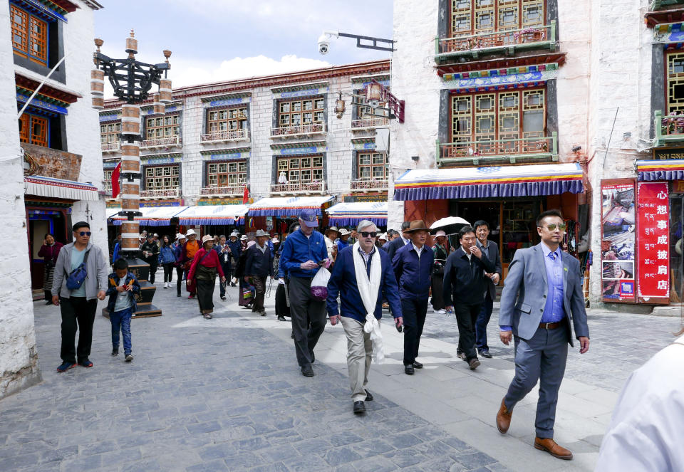 In this photo taken May 23, 2019, and released by the U.S. Embassy in Beijing, U.S. Ambassador to China Terry Branstad, center, walks along a street in Lhasa in western China's Tibet Autonomous Region. The U.S. ambassador to China urged Beijing to engage in substantive dialogue with exiled Tibetan Buddhist leader the Dalai Lama during a visit to the Himalayan region over the past week, the Embassy said Saturday. (U.S. Mission to China via AP)