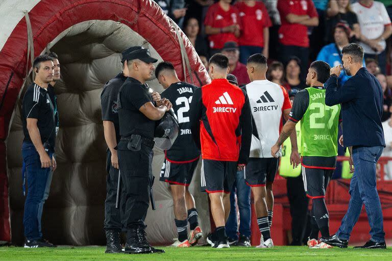 Los futbolistas de River se retiran del campo de juego; detrás de ellos, Martín Demichelis