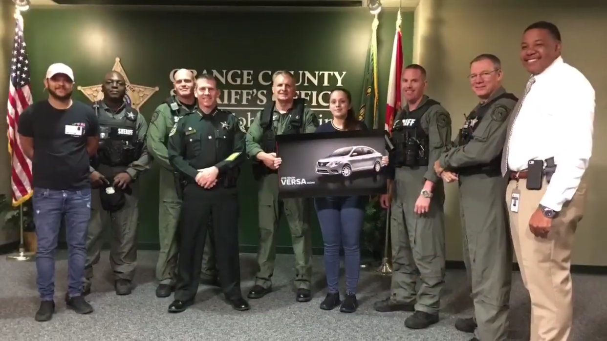 Samantha Rodriguez ist umringt von Orange County-Polizisten, sie trägt ein Bild ihres neuen Autos. Foto: Facebook / Orange County Sheriff’s Office Florida