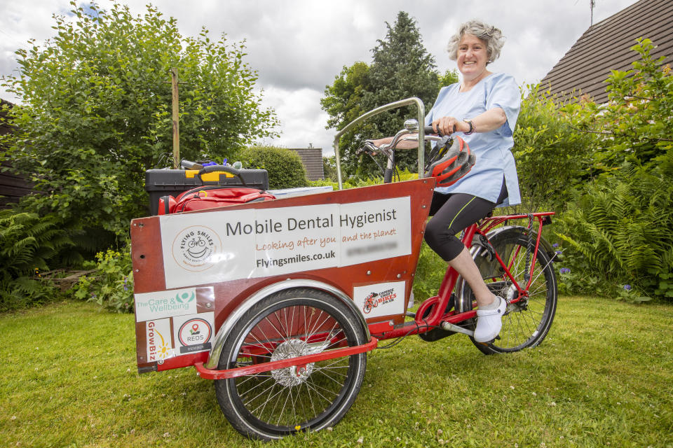 Perry cycles between houses with her equipment on a cargo bike. (SWNS)
