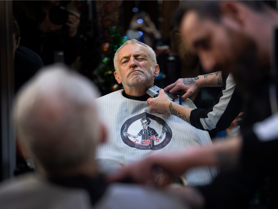 FILE - In this Saturday, Dec. 7, 2019 file photo Labour Party leader Jeremy Corbyn has his beard trimmed in Big Mel's Barbershop, Carmarthen, while on the General Election campaign trail in Wales. (Victoria Jones/PA via AP, File)