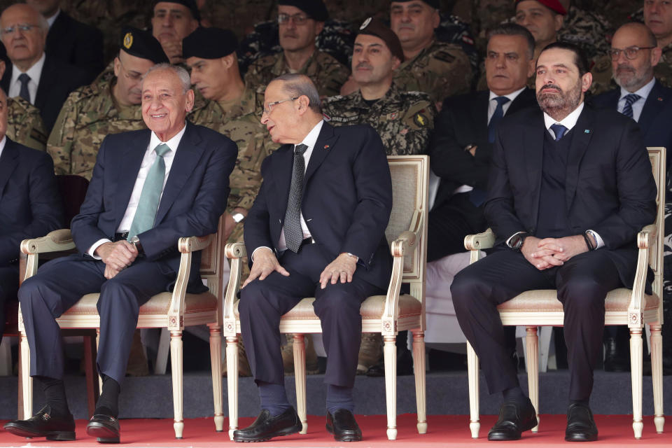 Lebanese President Michel Aoun, center, former Prime Minister Saad Hariri, right, and Lebanese Parliament Speaker Nabih Berri, left, attend a military parade to mark the 76th anniversary of Lebanon's independence from France at the Lebanese Defense Ministry, in Yarzeh near Beirut, Lebanon, Friday, Nov. 22, 2019. Lebanon's top politicians Friday attended a military parade on the country's 76th Independence Day, appearing for the first time since the government resigned amid nationwide protests now in their second month. (AP Photo/Hassan Ammar)