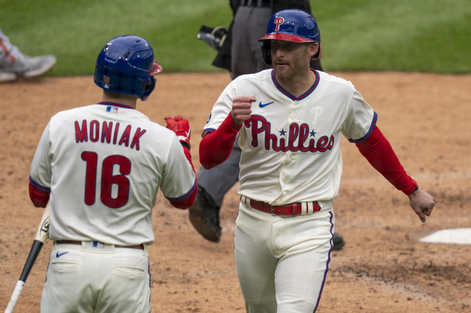 Philadelphia Phillies' Brad Miller, right, celebrates scoring on the hit by Nick Maton with Mickey Moniak, left, during the sixth inning of a baseball game, Wednesday, April 21, 2021, in Philadelphia. (AP Photo/Chris Szagola)