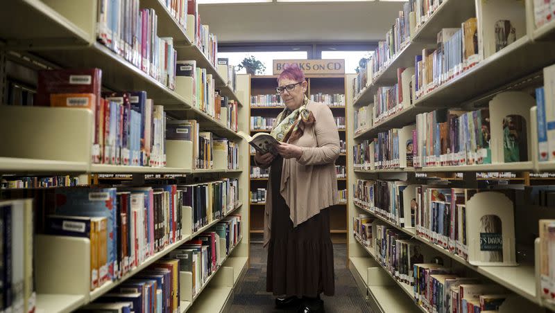 Wanda Mae Huffaker, a librarian with Salt Lake County Library, flips through a book at the Ruth Vine Tyler Library in Midvale on March 24, 2022. Last year saw a record number of book challenges nationally.