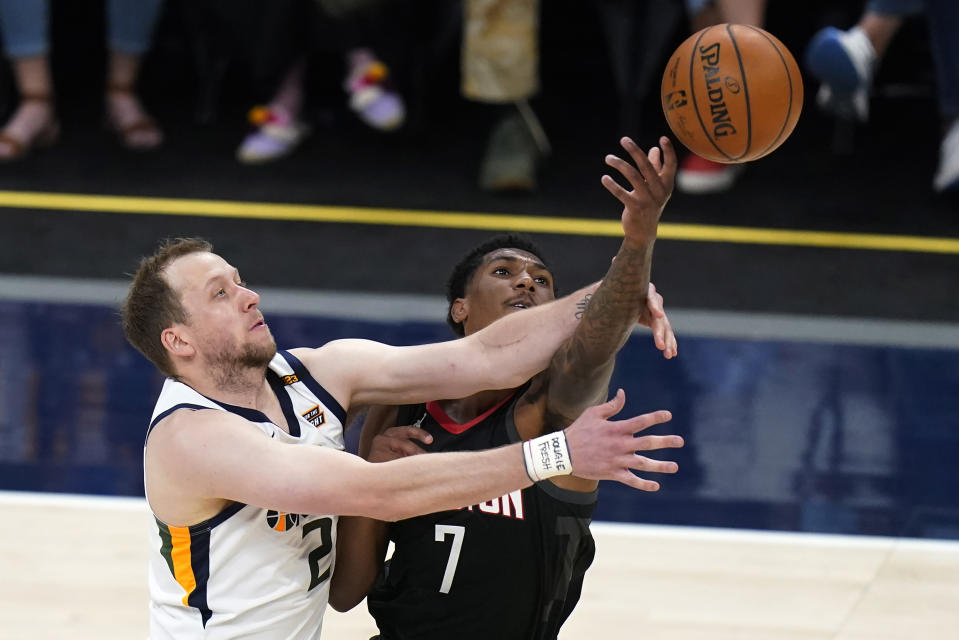 Utah Jazz guard Joe Ingles (2) and Houston Rockets guard Armoni Brooks (7) reach for the ball during the first half of an NBA basketball game Saturday, May 8, 2021, in Salt Lake City. (AP Photo/Rick Bowmer)