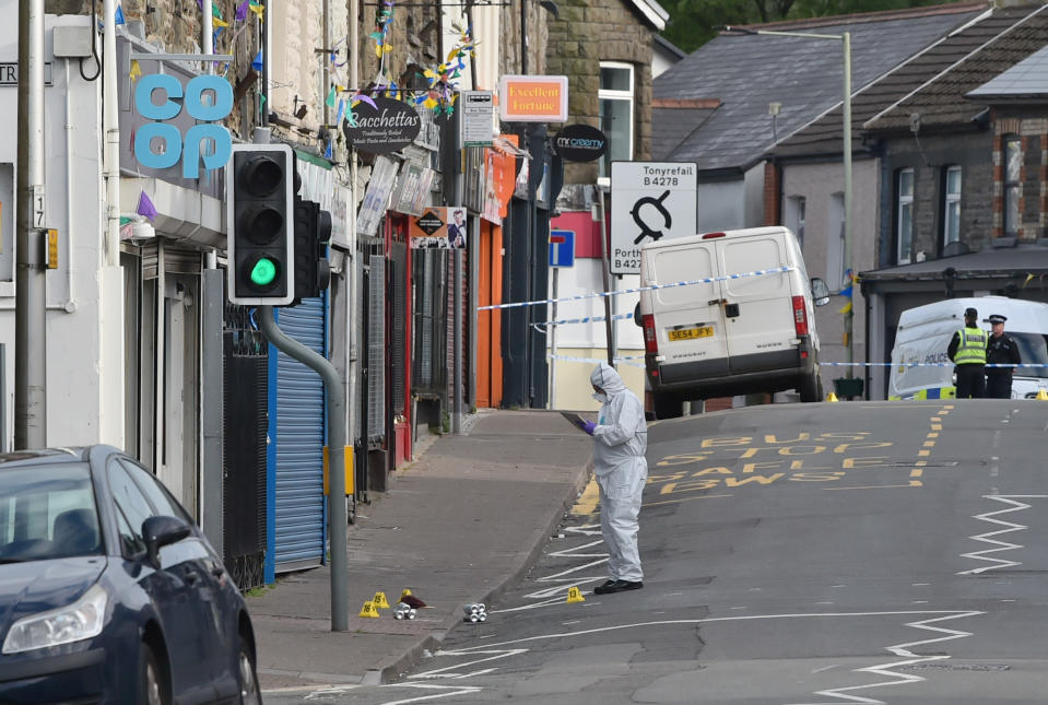 Forensic officers at the scene of a reported stabbing in the village of Pen Y Graig in South Wales.