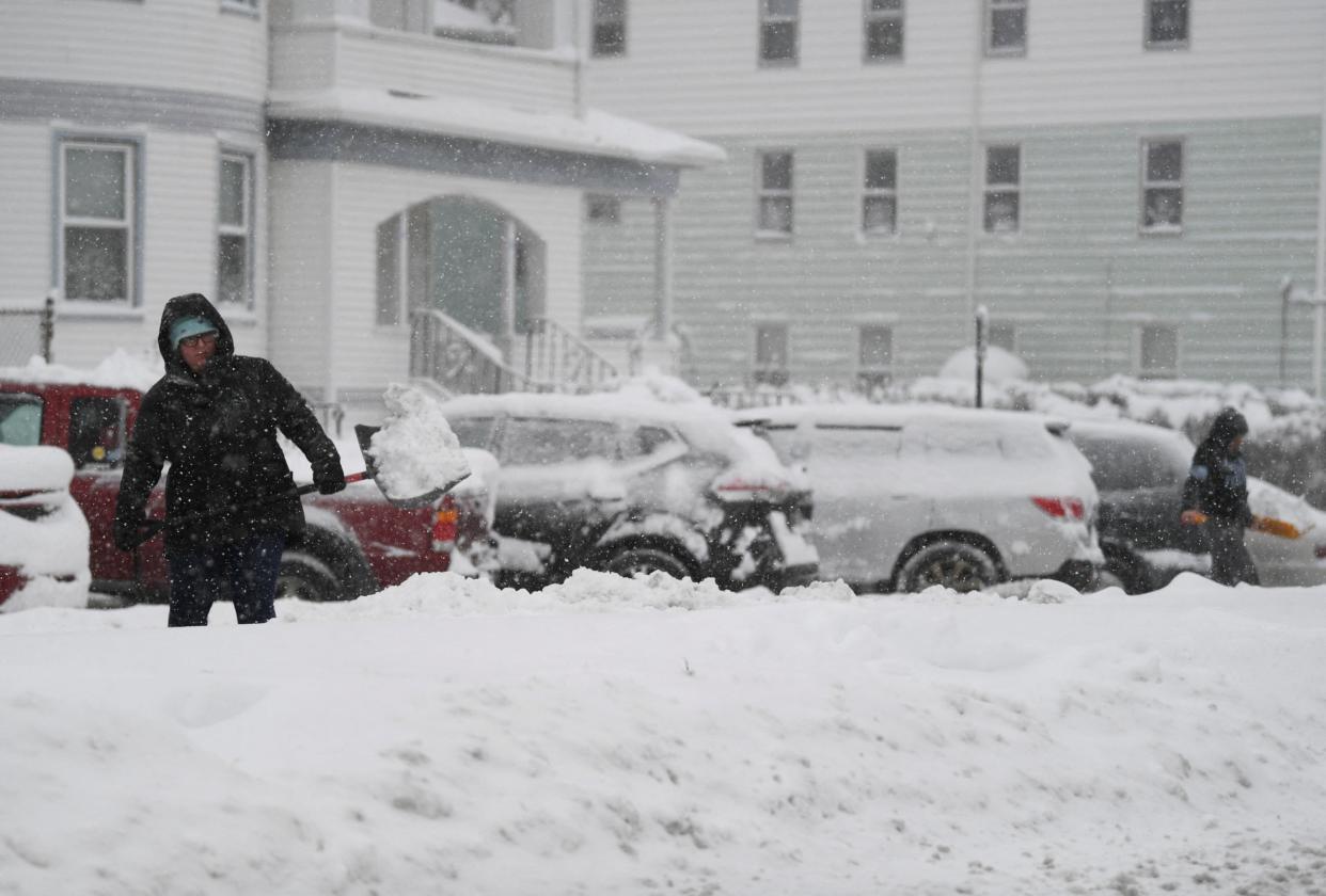 A woman throws snow while shovelling her car during the first winter storm of 2024 which is expected to bring heavy snowfall across the northeast United States (REUTERS)