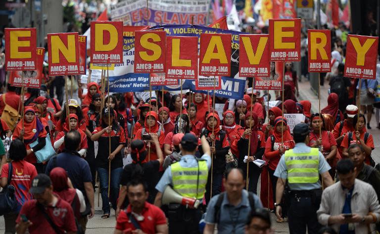 Migrant workers from Indonesia carry placards which collectively read "End Slavery" during a Labour Day rally in Hong Kong, on May 1, 2014