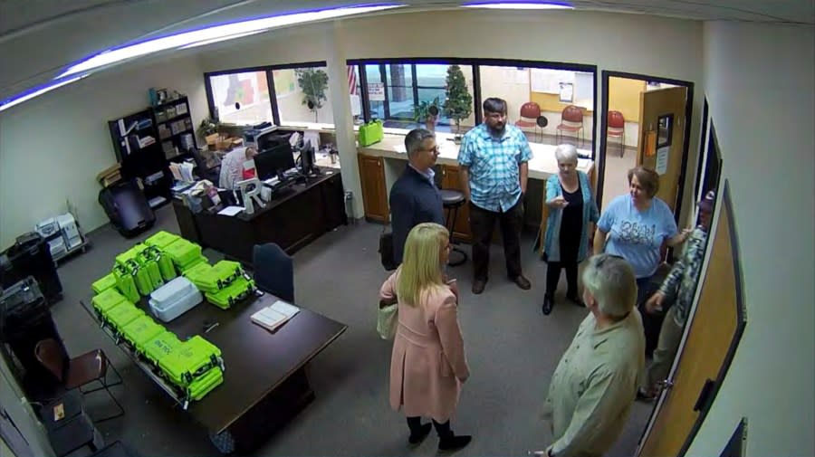 FILE – This Jan. 7, 2021, image taken from Coffee County, Ga., security video, appears to show Cathy Latham (center, long turquoise top), introducing members of a computer forensic team to local election officials. Latham was the county Republican Party chair at the time. The computer forensics team was at the county elections office in Douglas, Ga., to make copies of voting equipment in an effort that documents show was arranged by attorney Sidney Powell and others allied with then-President Donald Trump. (Coffee County, Georgia via AP)