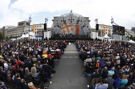 People attend a discussion by German Chancellor Angela Merkel and former U.S. President Barack Obama at the German Protestant Kirchentag in front of the Brandenburg Gate in Berlin, Germany, May 25, 2017. REUTERS/Fabrizio Bensch