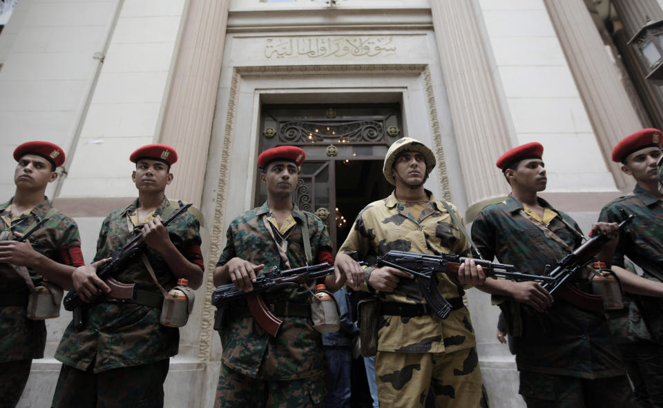 FILE - In this Wednesday, March 23, 2011 file photo, Egyptian army soldiers guard the entrance of Egypt's stock exchange in Cairo, Egypt . The Egyptian military receives around $1 billion a year in U.S. aid, one of the largest recipients. But its budget is largely unknown. Under Mubarak and previous leaders, the budget was discussed in a secret panel in parliament, dominated by ruling party officials and loyalists. (AP Photo/Nasser Nasser, File)