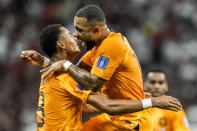 Cody Gakpo of the Netherlands, left, celebrates after scoring his side's opening goal during the World Cup group A soccer match between the Netherlands and Qatar, at the Al Bayt Stadium in Al Khor , Qatar, Tuesday, Nov. 29, 2022. (AP Photo/Moises Castillo)